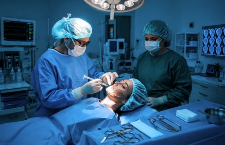Surgeons performing microvascular reconstructive surgery to restore oral function and facial structure after cancer treatment at an oral cancer hospital in Ahmedabad.