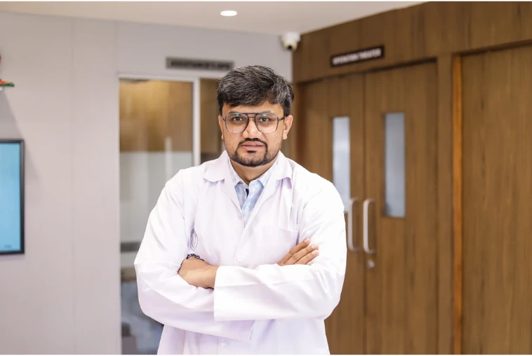 Oral and maxillofacial surgeon standing in a hospital setting, representing expertise in craniofacial surgery, craniofacial reconstruction surgery, skull base surgery ENT, and advanced head and neck tumour treatment in Ahmedabad.